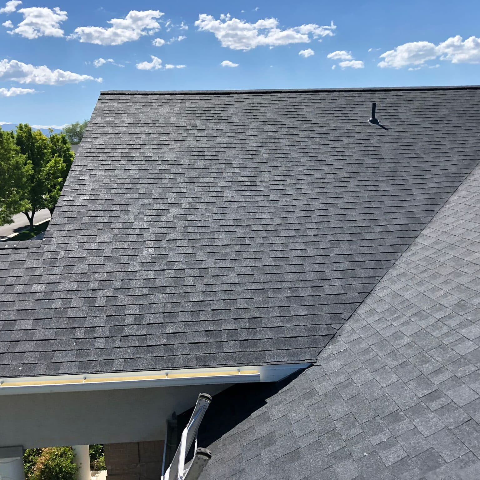Clean dark shingle roof under blue sky