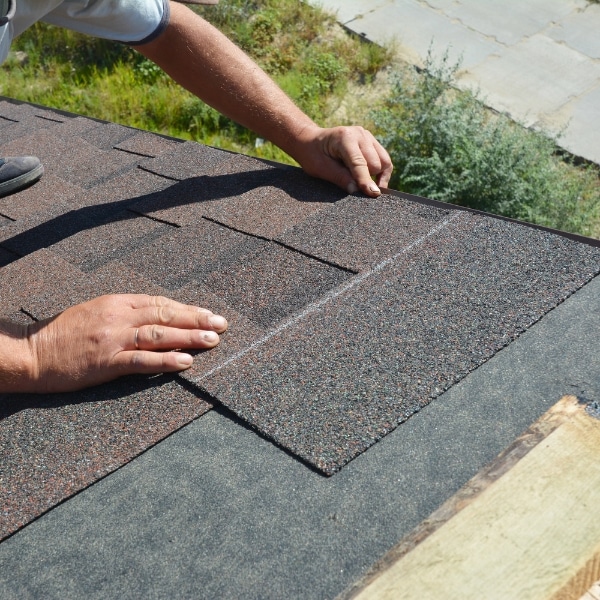 Technician performing residential roof repair in West Jordan, Utah