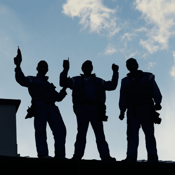 Roofing team standing in front of Intermountain West Contractors vehicle
